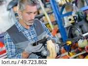 a small engine mechanic working. Стоковое фото, агентство Ingram Publishing / Фотобанк Лори