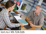 saleswoman and client at cash counter in hardware store. Стоковое фото, агентство Ingram Publishing / Фотобанк Лори