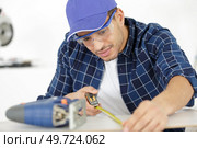 the builder worker measures something. Стоковое фото, агентство Ingram Publishing / Фотобанк Лори