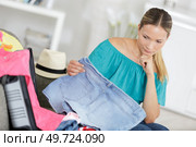 woman packing her clothes into an open suitcase. Стоковое фото, агентство Ingram Publishing / Фотобанк Лори