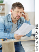 concentrated man does understand furniture. Стоковое фото, агентство Ingram Publishing / Фотобанк Лори