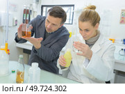 two scientists making experiments with different liquids. Стоковое фото, агентство Ingram Publishing / Фотобанк Лори