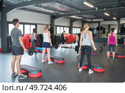 young sporty people training with steppers in gym. Стоковое фото, агентство Ingram Publishing / Фотобанк Лори