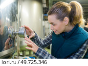 female wine house worker checking quality of product in cellar. Стоковое фото, агентство Ingram Publishing / Фотобанк Лори