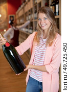 woman in off-license holding a magnum of champagne. Стоковое фото, агентство Ingram Publishing / Фотобанк Лори