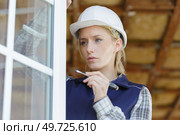 woman builder unscrews fastening screws handle window. Стоковое фото, агентство Ingram Publishing / Фотобанк Лори