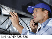 man repairing a tv roof antenna. Стоковое фото, агентство Ingram Publishing / Фотобанк Лори