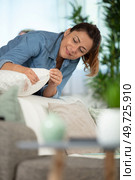woman is tidying up a pillow. Стоковое фото, агентство Ingram Publishing / Фотобанк Лори