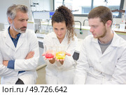 scientific laboratory researchers perform tests with liquids. Стоковое фото, агентство Ingram Publishing / Фотобанк Лори