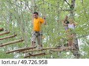 visitors in adventure park on rope bridge. Стоковое фото, агентство Ingram Publishing / Фотобанк Лори