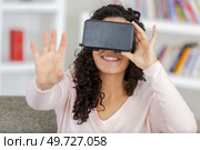 young woman wearing a virtual reality headset at home. Стоковое фото, агентство Ingram Publishing / Фотобанк Лори