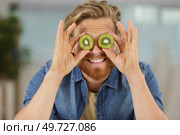 comical image of man covering eyes with kiwi slices. Стоковое фото, агентство Ingram Publishing / Фотобанк Лори