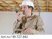 builder talking on portable uhf radio transceiver. Стоковое фото, агентство Ingram Publishing / Фотобанк Лори