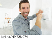 installing a programmable room thermostat. Стоковое фото, агентство Ingram Publishing / Фотобанк Лори