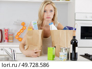 tired woman having back problems after groceries shopping. Стоковое фото, агентство Ingram Publishing / Фотобанк Лори