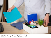 midsection view of a businessman tiddy belongings in cardboard box. Стоковое фото, агентство Ingram Publishing / Фотобанк Лори