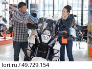 cheerful couple looking at a motorcycle at a salon. Стоковое фото, агентство Ingram Publishing / Фотобанк Лори