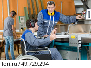 disabled worker in wheelchair in factory on the machine. Стоковое фото, агентство Ingram Publishing / Фотобанк Лори