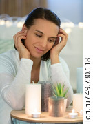 happy young woman looks dreamily at some candles. Стоковое фото, агентство Ingram Publishing / Фотобанк Лори