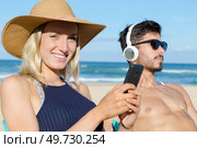 couple on the beach using technological devices. Стоковое фото, агентство Ingram Publishing / Фотобанк Лори