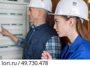 woman and teacher measuring electrical current of a fuse board. Стоковое фото, агентство Ingram Publishing / Фотобанк Лори