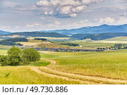Slovakia summer landscape. Green summer fields, meadows, hills of Tatra mountains. Travel in vacations. Rural Road in Spis region, Slovakia. Spissky hrad national park on background. Стоковое фото, агентство Ingram Publishing / Фотобанк Лори