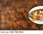 Fried tilapia fish with fruit in white plate. Lunch menu. Space for text.. Roasted whole tilapia or Mujair. Стоковое фото, агентство Ingram Publishing / Фотобанк Лори