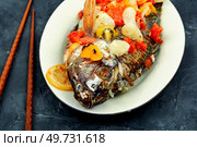 Fried tilapia fish with fruit. Healthy food concept.. Roasted whole tilapia with citrus sauce. Стоковое фото, агентство Ingram Publishing / Фотобанк Лори