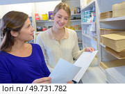 Woman in stationery shop looking at paper thickness. Стоковое фото, агентство Ingram Publishing / Фотобанк Лори