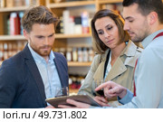 sommelier with couple choosing a bottle of wine. Стоковое фото, агентство Ingram Publishing / Фотобанк Лори