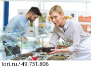 confectioner boxing customers choice of sweets from counter. Стоковое фото, агентство Ingram Publishing / Фотобанк Лори