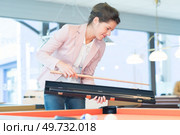 beautiful brunette keeping her billiard cue. Стоковое фото, агентство Ingram Publishing / Фотобанк Лори