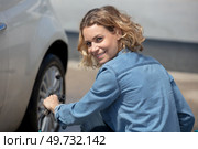 young woman changing car wheel. Стоковое фото, агентство Ingram Publishing / Фотобанк Лори