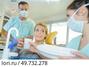 dentist curing a woman patient in the dental office. Стоковое фото, агентство Ingram Publishing / Фотобанк Лори