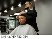 bearded man cutting his beard in the barbershop at the master. Стоковое фото, агентство Ingram Publishing / Фотобанк Лори