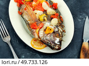 Fried yummy tilapia fish with fruit. Popular Malay or Indonesian food.. A view of a plate of fried tilapia. Стоковое фото, агентство Ingram Publishing / Фотобанк Лори