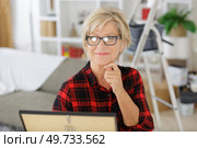 retired senior woman looking at photograph. Стоковое фото, агентство Ingram Publishing / Фотобанк Лори