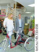 a man is looking at a tricycle. Стоковое фото, агентство Ingram Publishing / Фотобанк Лори