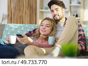 loving couple snuggling on sofa with cup of tea. Стоковое фото, агентство Ingram Publishing / Фотобанк Лори