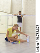Lady stretching leg out on badminton court. Стоковое фото, агентство Ingram Publishing / Фотобанк Лори