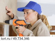 young woman with toolbelt using drill repair and renovation. Стоковое фото, агентство Ingram Publishing / Фотобанк Лори