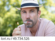 man smoking a cigarette outdoors. Стоковое фото, агентство Ingram Publishing / Фотобанк Лори
