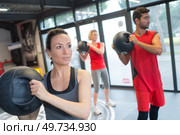 People in fitness class holding round prop. Стоковое фото, агентство Ingram Publishing / Фотобанк Лори