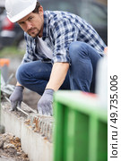 male construction worker aligning reinforcement bars. Стоковое фото, агентство Ingram Publishing / Фотобанк Лори
