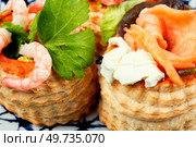 Puff pastry tartlets or canapes with smoked salmon, shrimp and bacon.. Tartlets with seafood and bacon, tasty snack. Стоковое фото, агентство Ingram Publishing / Фотобанк Лори