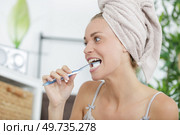portrait of beautiful young woman brushing her teeth. Стоковое фото, агентство Ingram Publishing / Фотобанк Лори