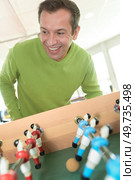 a man playing table football. Стоковое фото, агентство Ingram Publishing / Фотобанк Лори