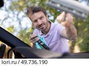man washes the windshield of the car with a brush. Стоковое фото, агентство Ingram Publishing / Фотобанк Лори