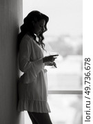 brown-haired girl in the morning in a bathrobe in the hotel corridor with a glass of white wine. Стоковое фото, агентство Ingram Publishing / Фотобанк Лори
