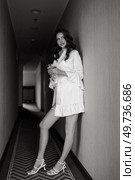 brown-haired girl in the morning in a bathrobe in the hotel corridor with a glass of white wine. Стоковое фото, агентство Ingram Publishing / Фотобанк Лори